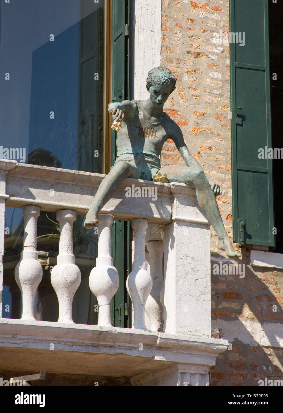 Sculpture of a young boy on a balcony in Venice Italy Stock Photo