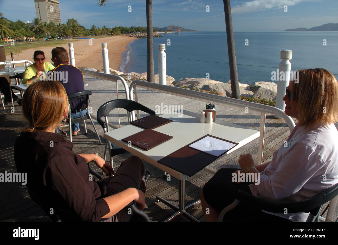 Breakfast at cafe overlooking The Strand, Townsville's city beach, with Magnetic Island visible across the bay, Queensland Stock Photo