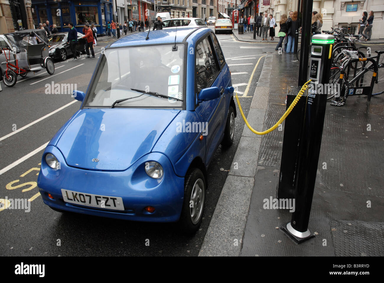 An electric car (a Reva G Wiz carbon neutral electric car) charges up using  a street juice point in central London Stock Photo - Alamy