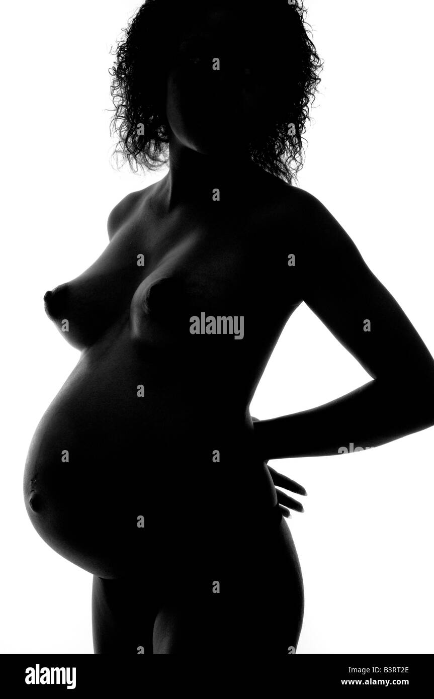 Naked black afro-Caribbean nude young teenage woman girl 7 months pregnant, swollen belly and full breasts, studio photograph Stock Photo