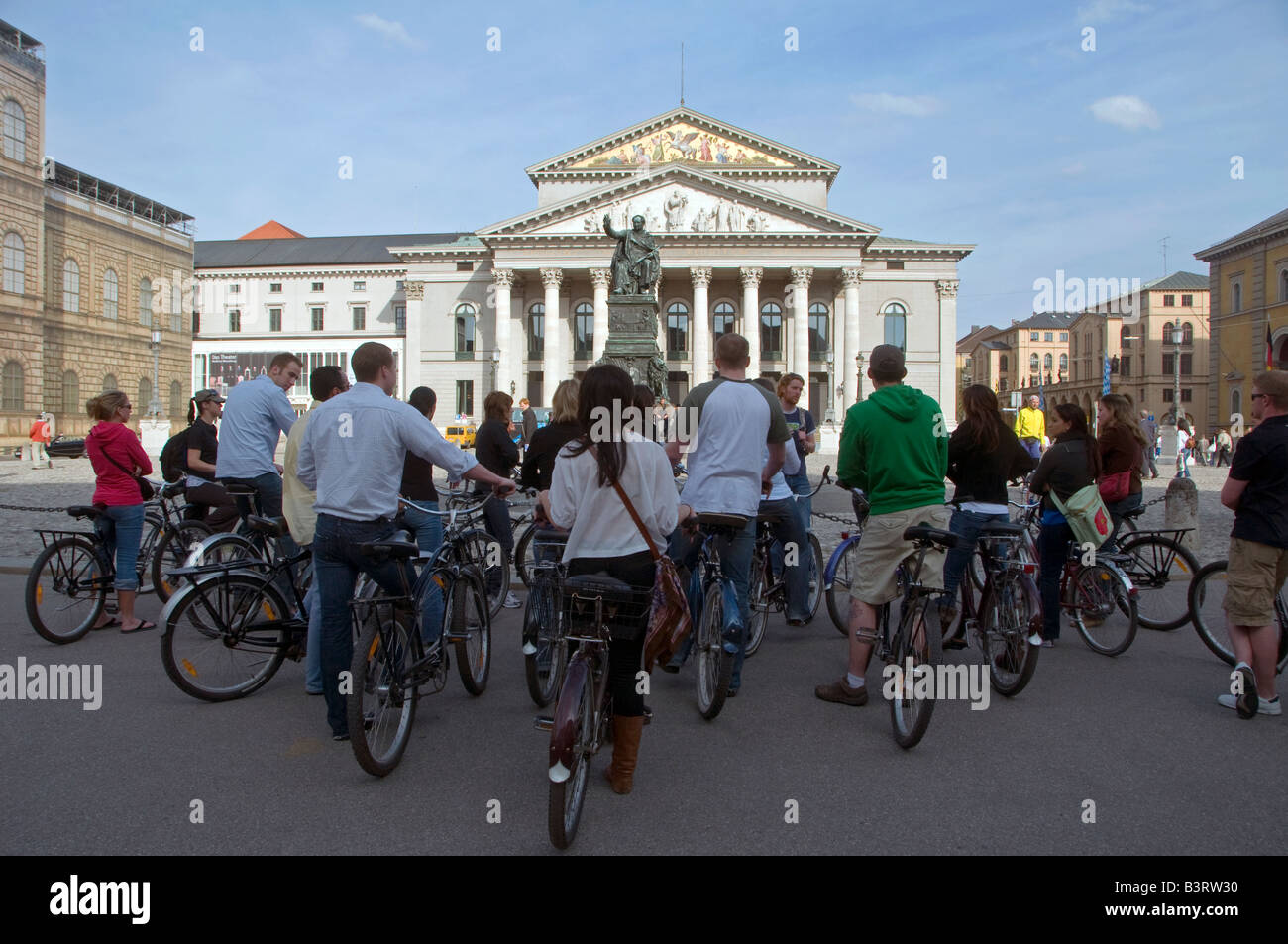 A guided bicycle tour in front of Max Joseph Platz & National Theater.in the city of Munich capital of Bavaria Germany Stock Photo