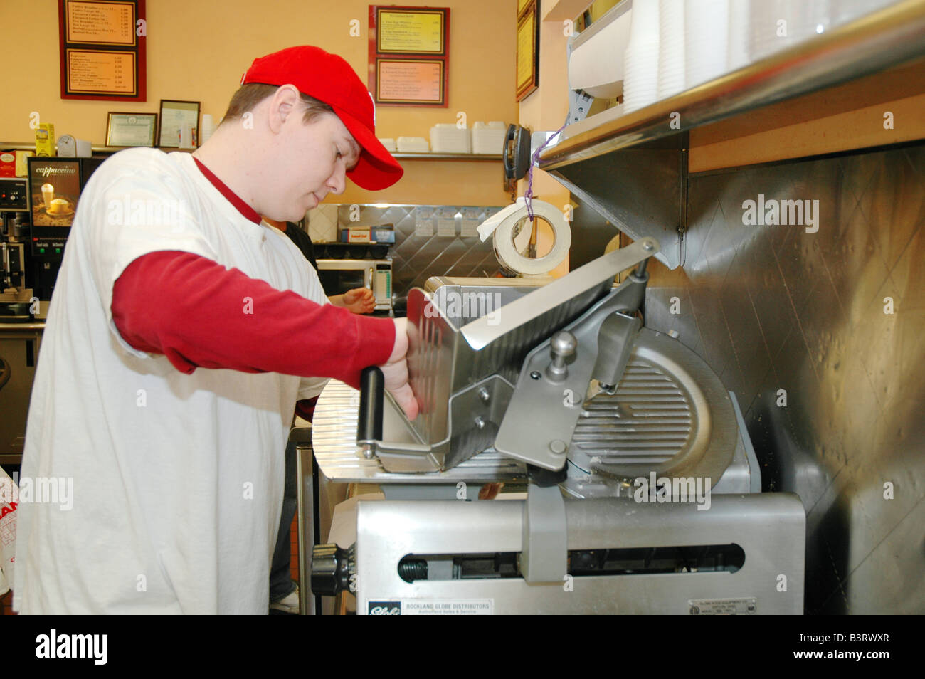 man slicing meat on slicing machine at a deli brooklyn new york Stock