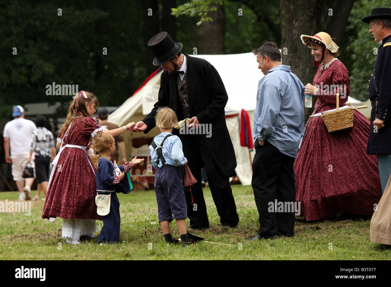 President Abraham Lincoln handing coins to children at a Civil War Encampment Reenactment Stock Photo
