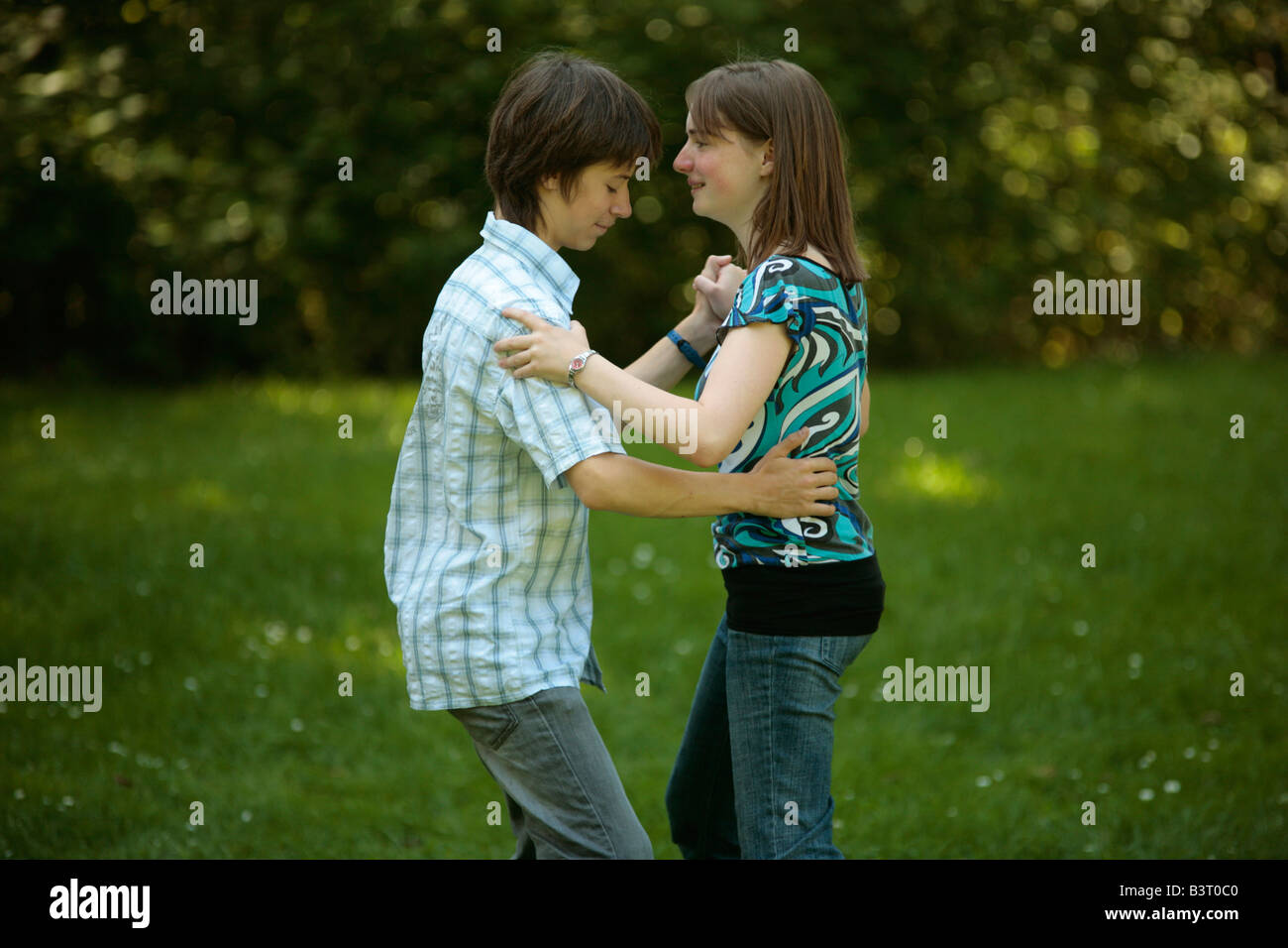 teenage girl teaching a boy how to dance (in vain) Stock Photo