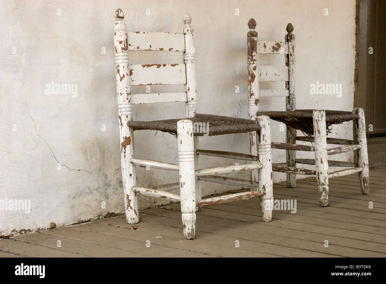 Two antique chairs sitting on a porch Stock Photo - Alamy