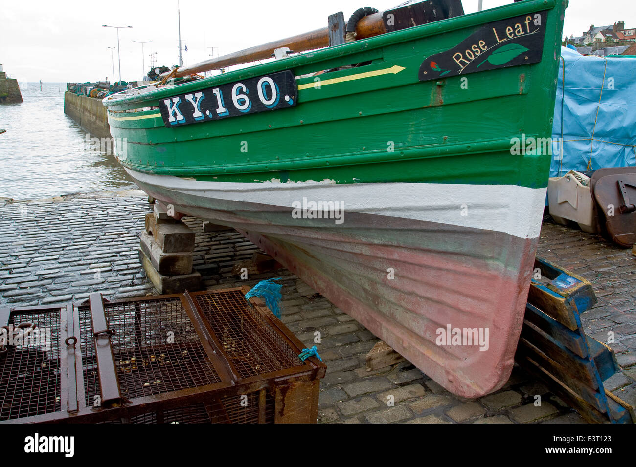 A small fishing boat on the side of a Scottish harbour Stock Photo