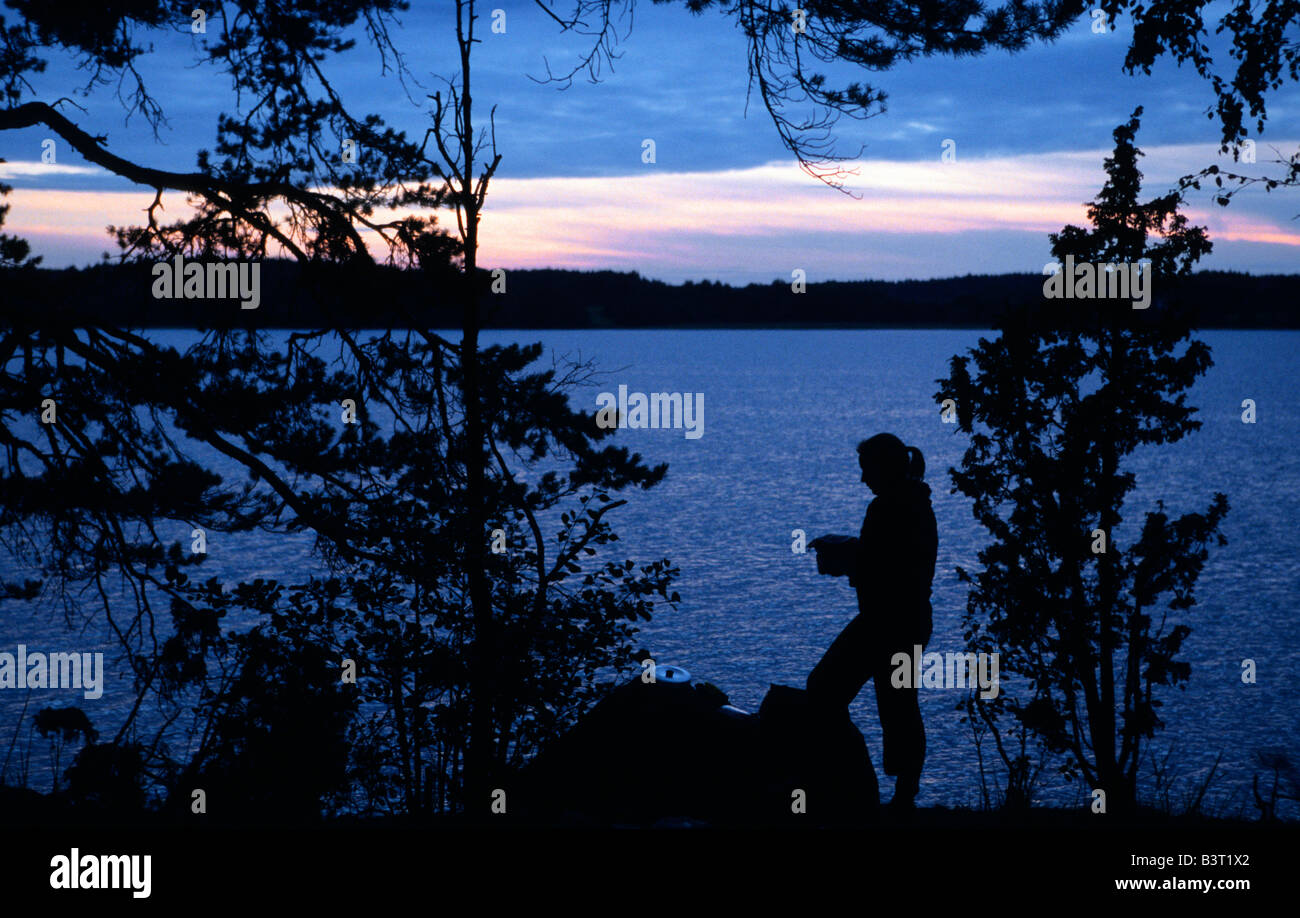 Silhouette of a woman in twilight at a lake near Flen and Nykoping Sodermanlands Lan Sweden August 2006 Stock Photo