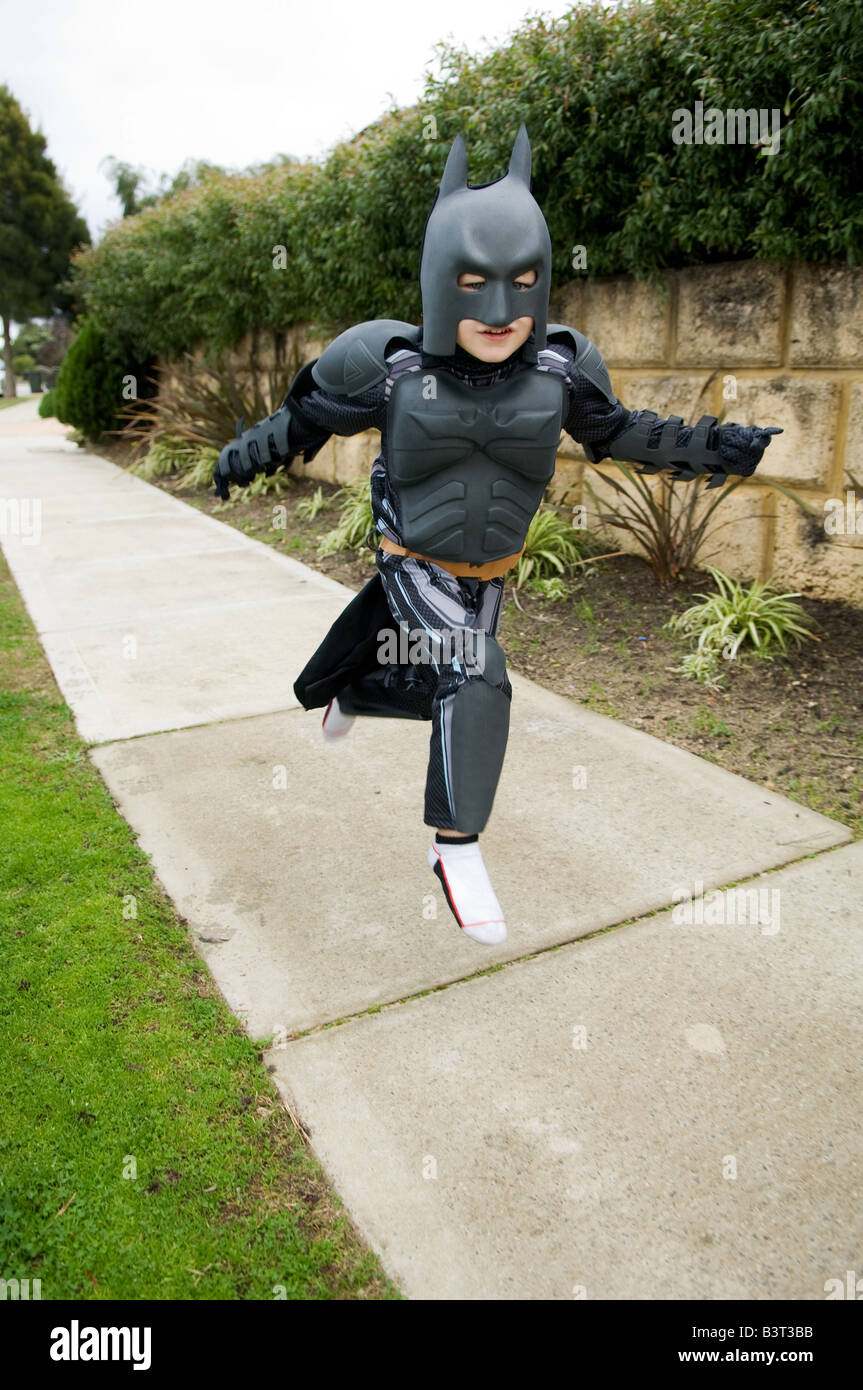 Portraits of young four year old boy dressed up in Batman suit through the  air and appearing to fly down the footpath Stock Photo - Alamy
