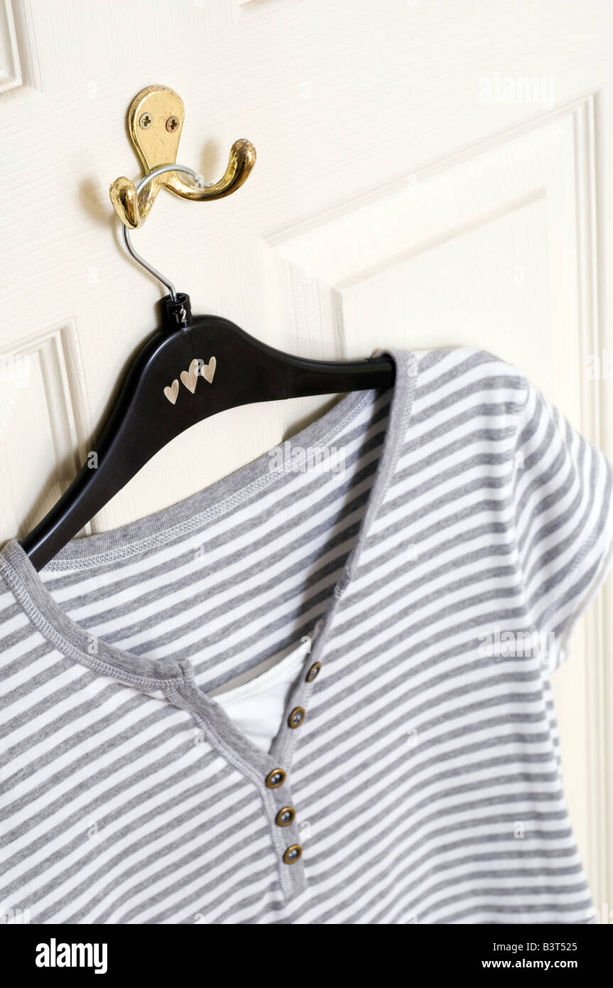 ladies summer t shirt hanging on a hook on the back of a white door