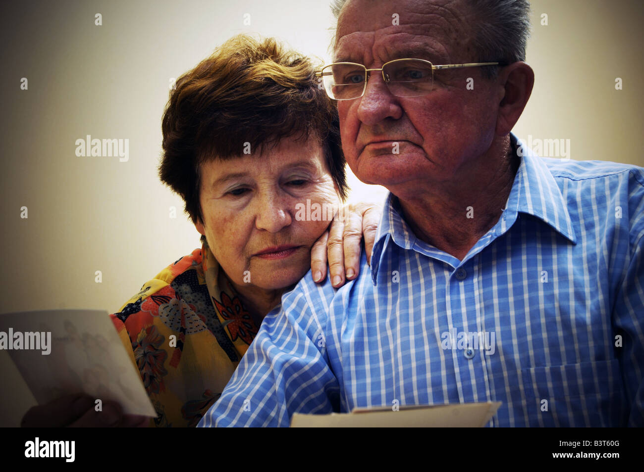 Senior couple looking at old photographs. Reminisce about the past Stock Photo