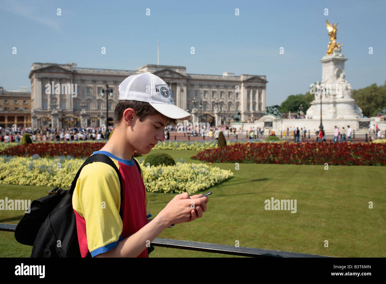 teenage boy waiting for the Changing of the Guard outside Buckingham Palace in London Stock Photo