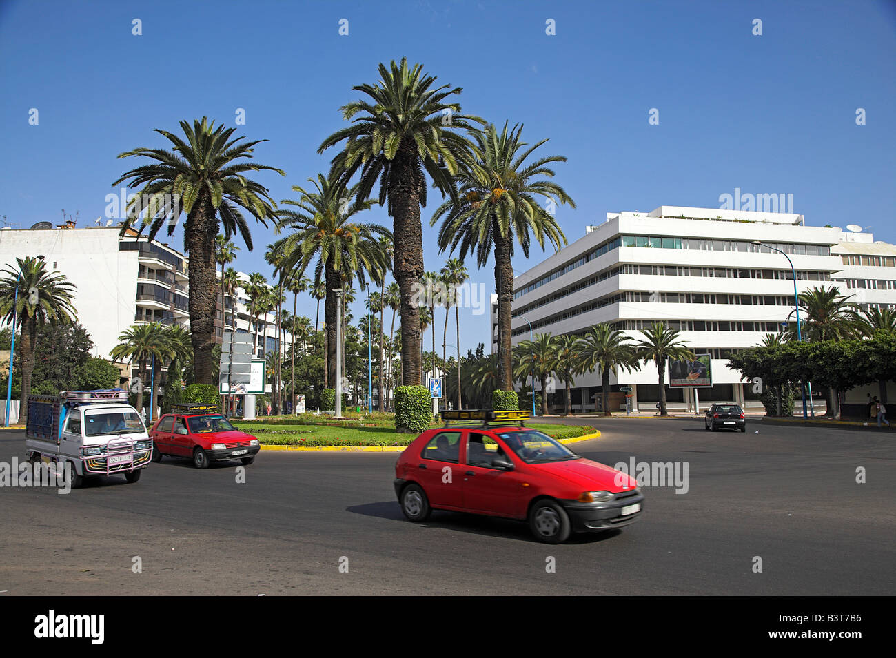 Morocco, Maghreb, Casablanca. A red Petit Taxi passes through the modern business district of Gauthier. Stock Photo