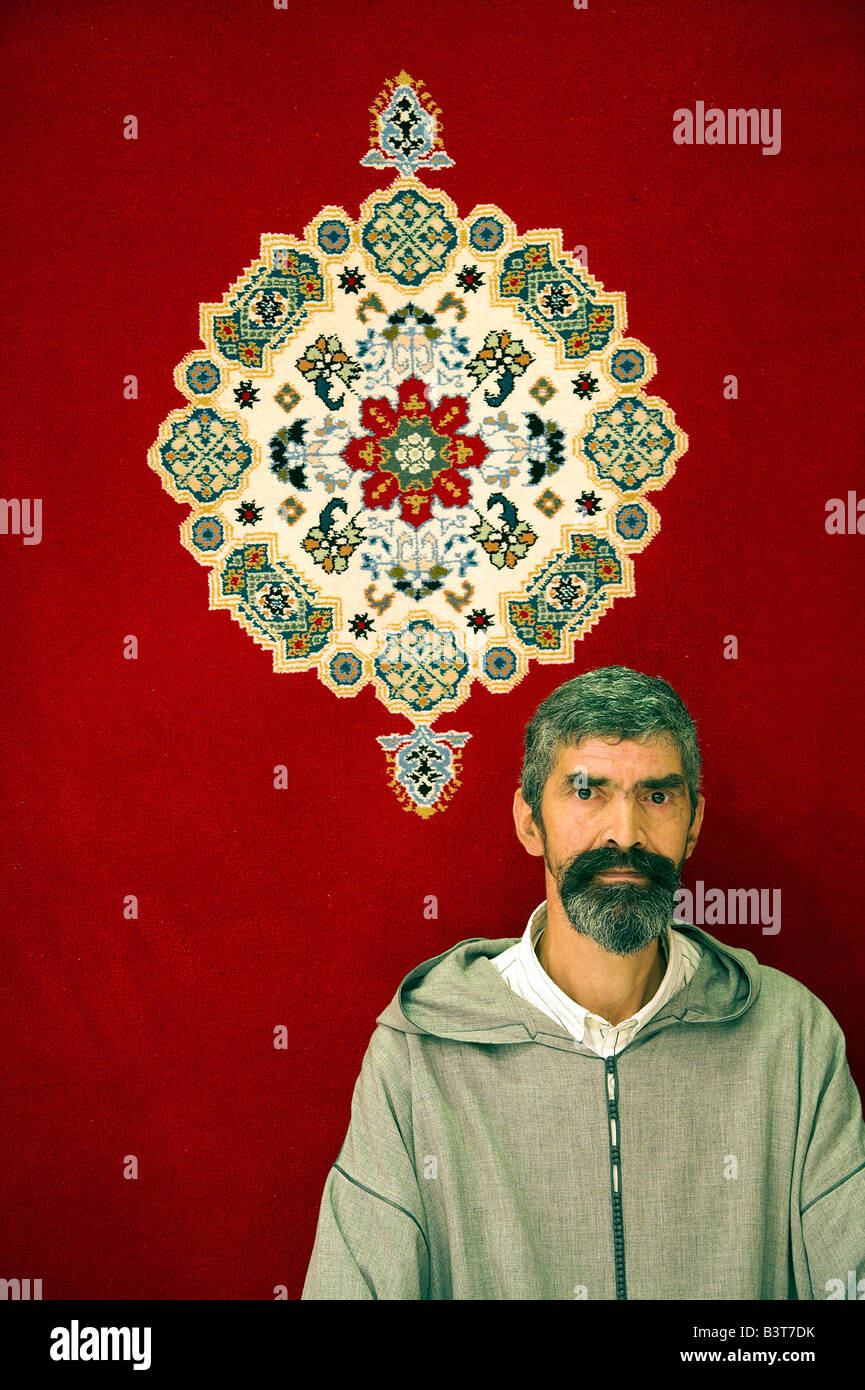 A traditional Moroccan carpet salesman shows off his wares in the souq