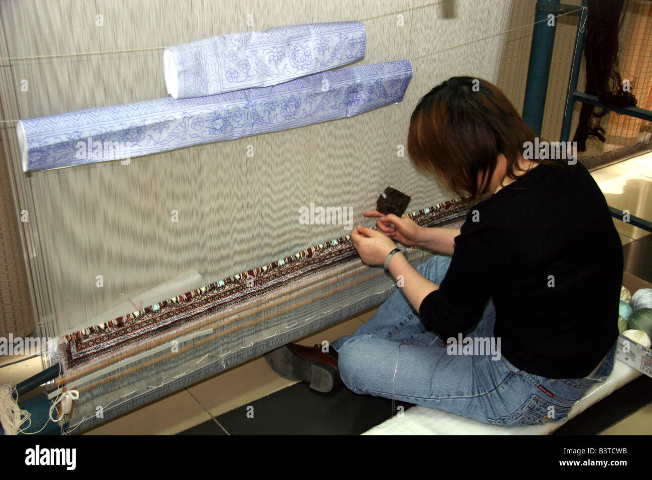 Asia, China, Beijing. Silk Carpet Weaver and loom Stock Photo