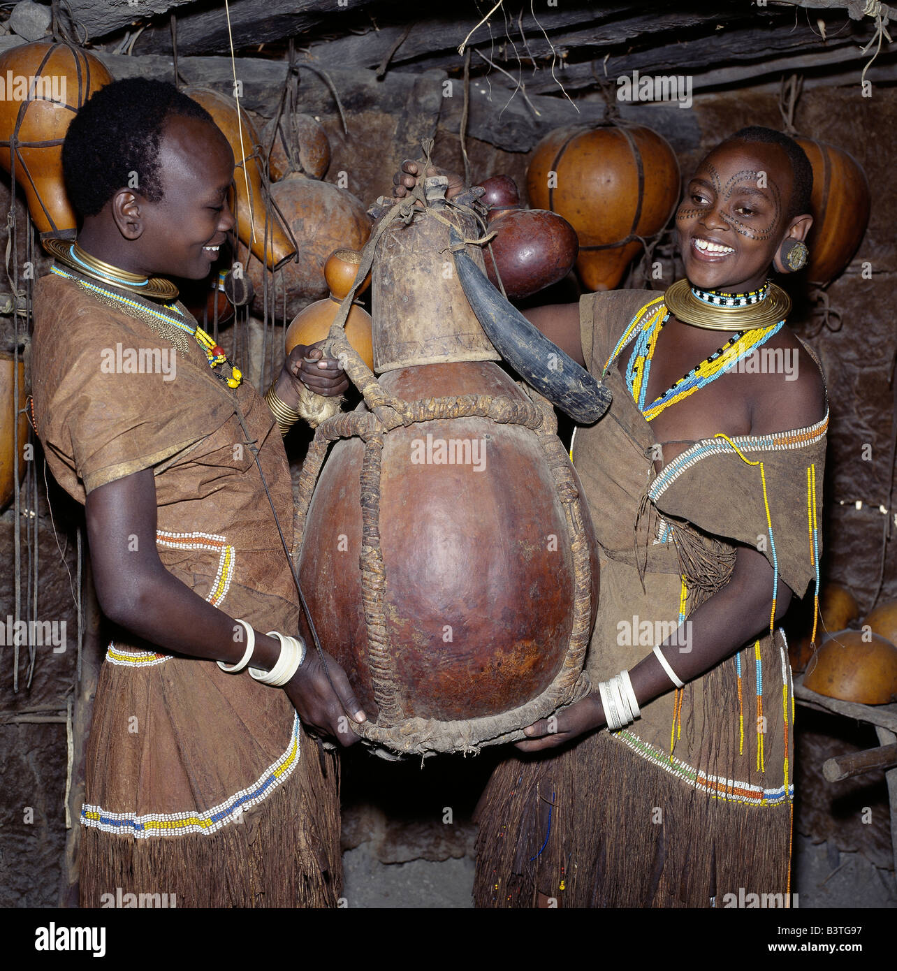 Tanzania, Ngorongoro Highlands, Eyasi escarpment. Two Datoga women carry from their home a large gourd, which will be used for f Stock Photo
