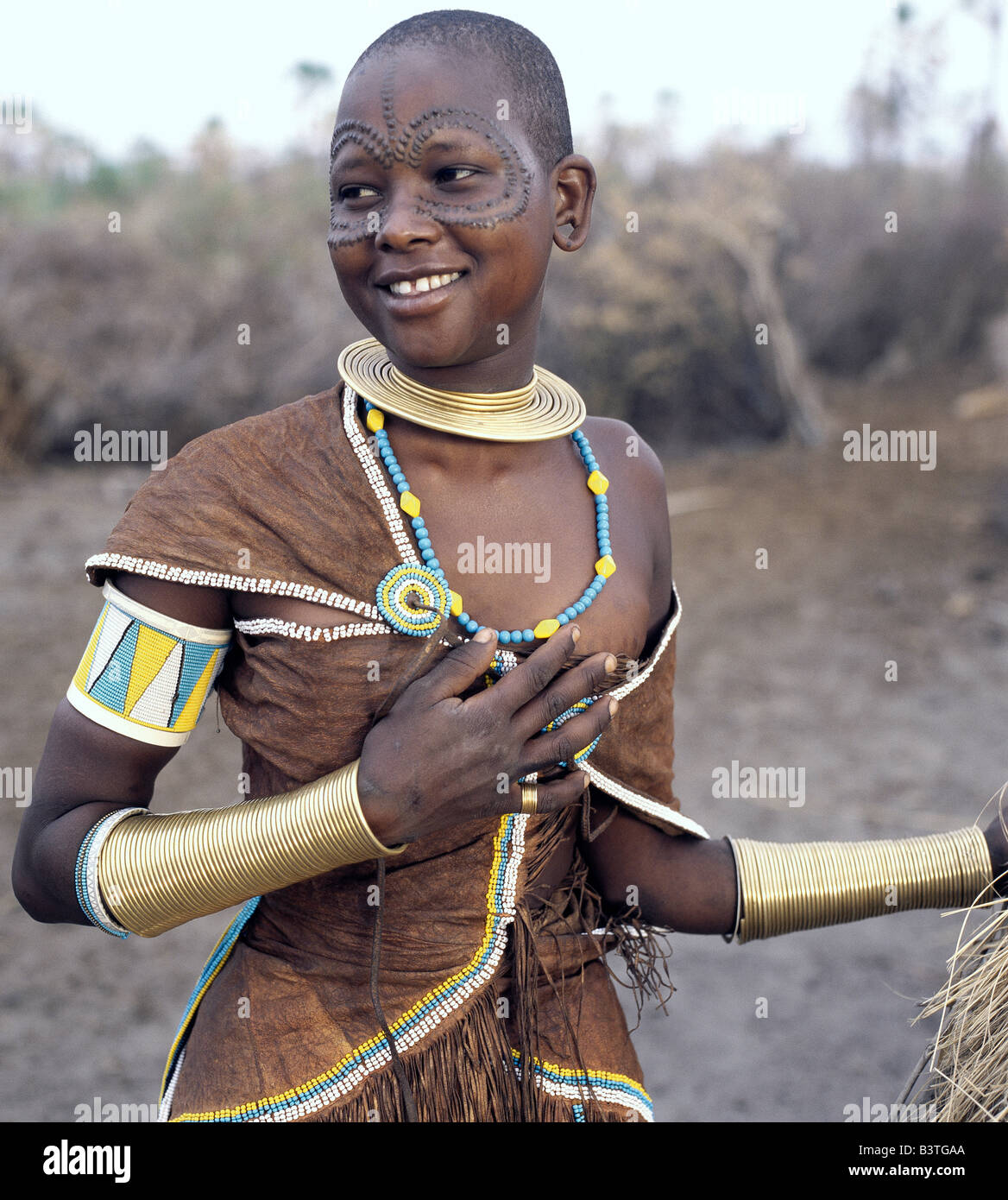 Tanzania, Northern Tanzania, Manyara. A Datoga woman relaxes outside her thatched house. The traditional attire of Datoga women Stock Photo