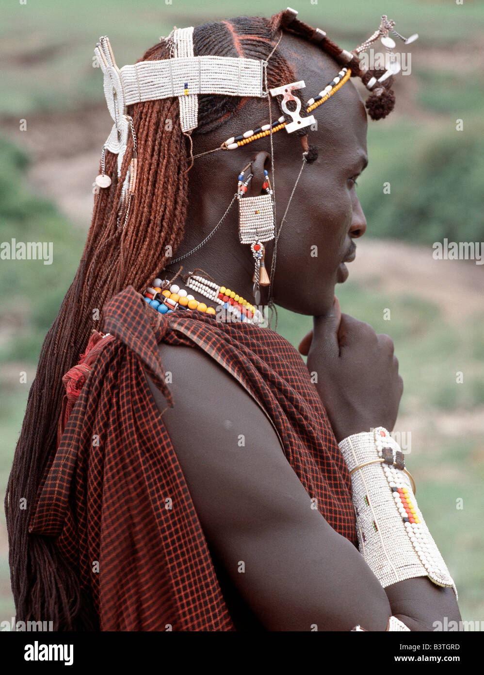 Tanzania, Northern Tanzania, Kerimasi. A warrior of the Kisongo section of the Maasai with his long Ochred braids decorated with beaded ornaments. His broad armulet is typical of the Kisongo living in northern Tanzania where white is the preferred colour of their beadwork. Stock Photo