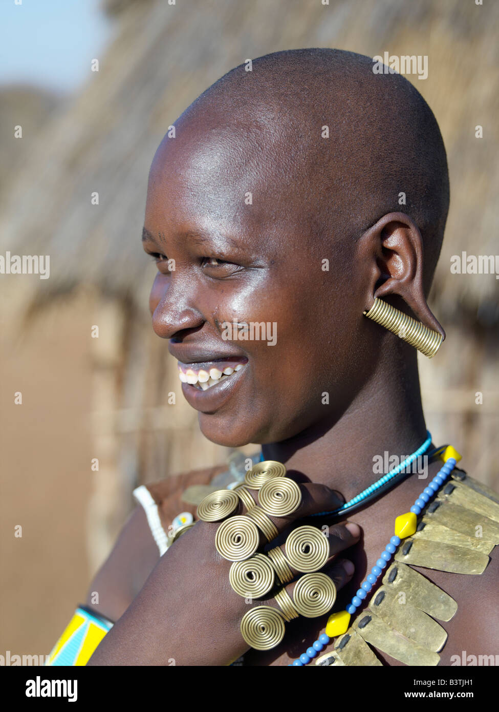 Tanzania, Northern Tanzania, Balangida Lelu. A Datoga woman in jovial mood. The traditional attire of Datoga women includes beautifully tanned and decorated leather dresses and coiled brass armbands, necklaces, earrings and rings. Yellow and light blue are the preferred colours of the beads they wear. Scarification of the face is not uncommon among women and girls.The Datoga (known to their Maasai neighbours as the Mang'ati and to the Iraqw as Babaraig) live in northern Tanzania and are primarily pastoralists. Stock Photo