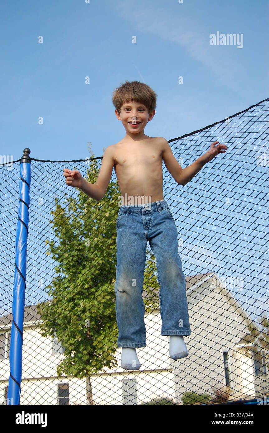 Six year old child captured in mid air jumping on trampoline Stock Photo