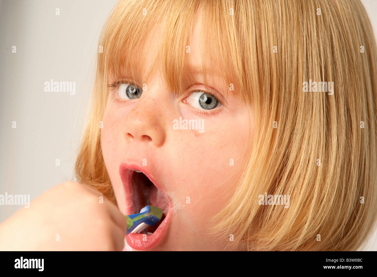 A young girl cleaning her teeth Stock Photo