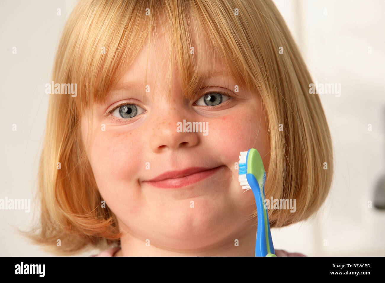 A young girl holding a toothbrush Stock Photo
