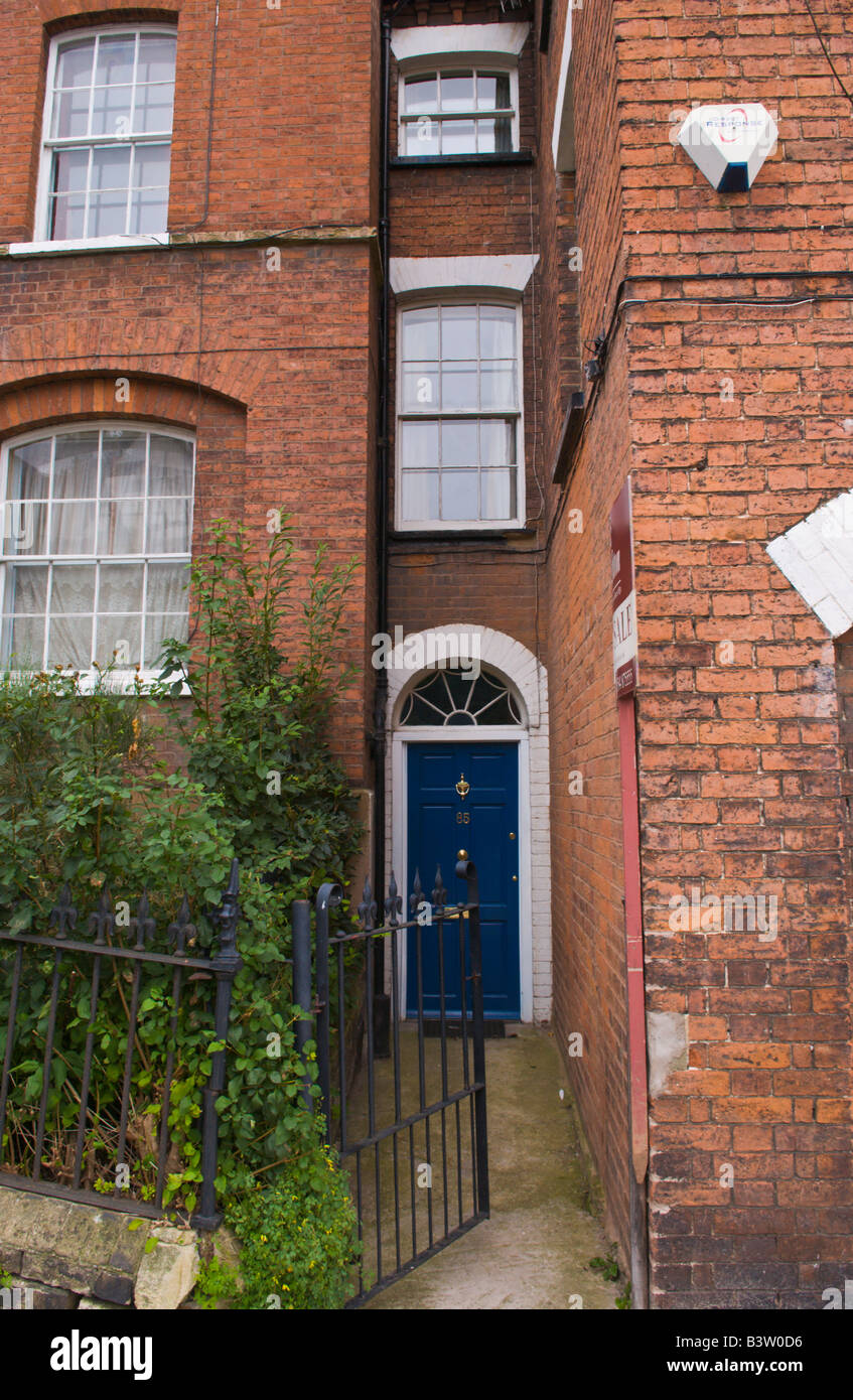 Blue front door with semicircular glazed fanlight of narrow entrance to townhouse in Ludlow