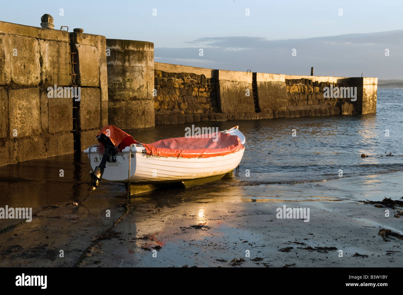 Small motor boat moored at Beadnell Harbour in Northumberland Great Britain Stock Photo