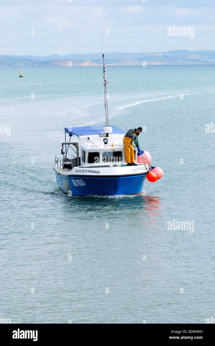 Fishing boat heading into the harbour at Lyme Regis in Dorset Stock ...
