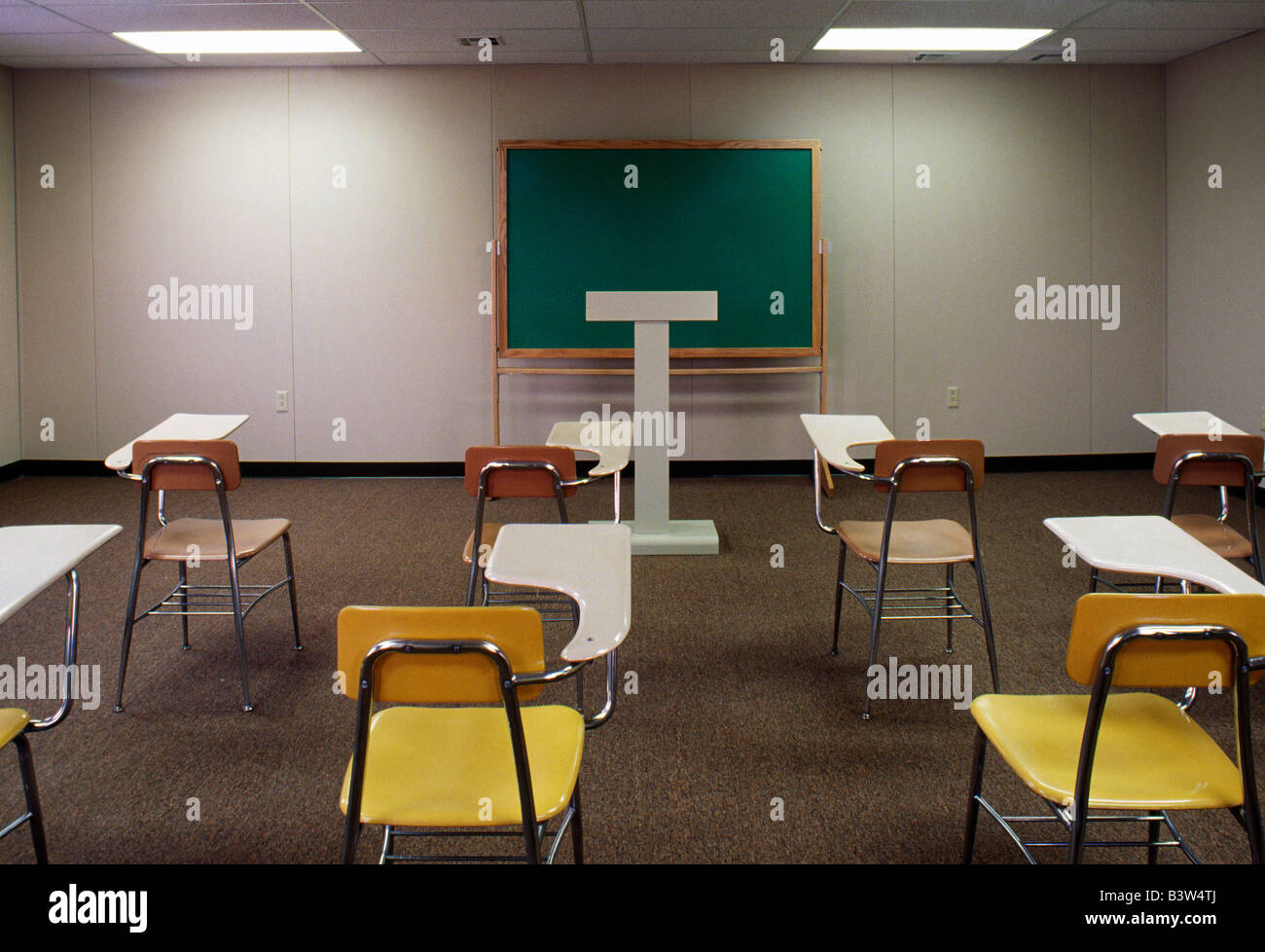 Desks, chairs, podium and blackboard in the classroom of a community college. Stock Photo