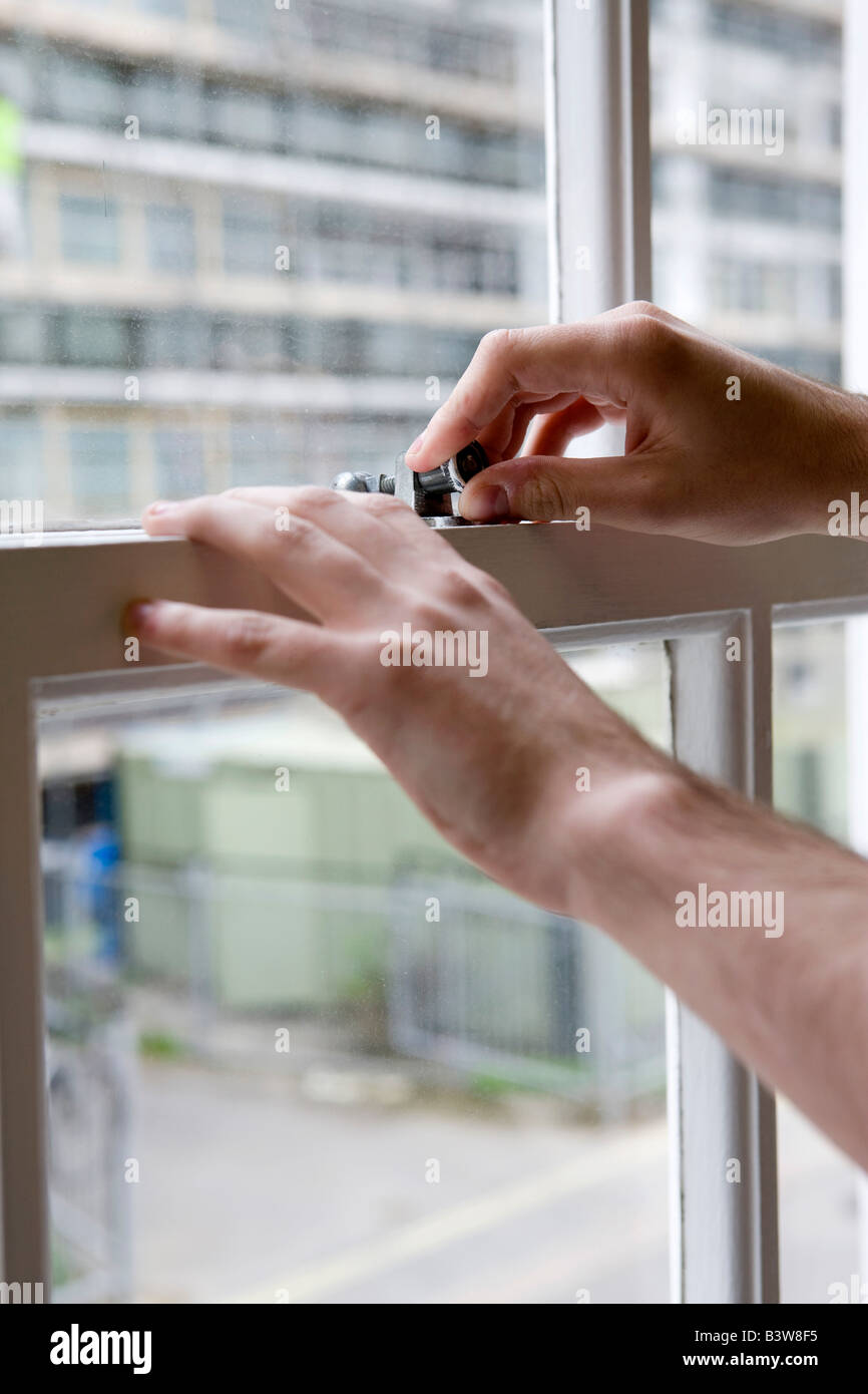 hands securing lock on window Stock Photo Alamy