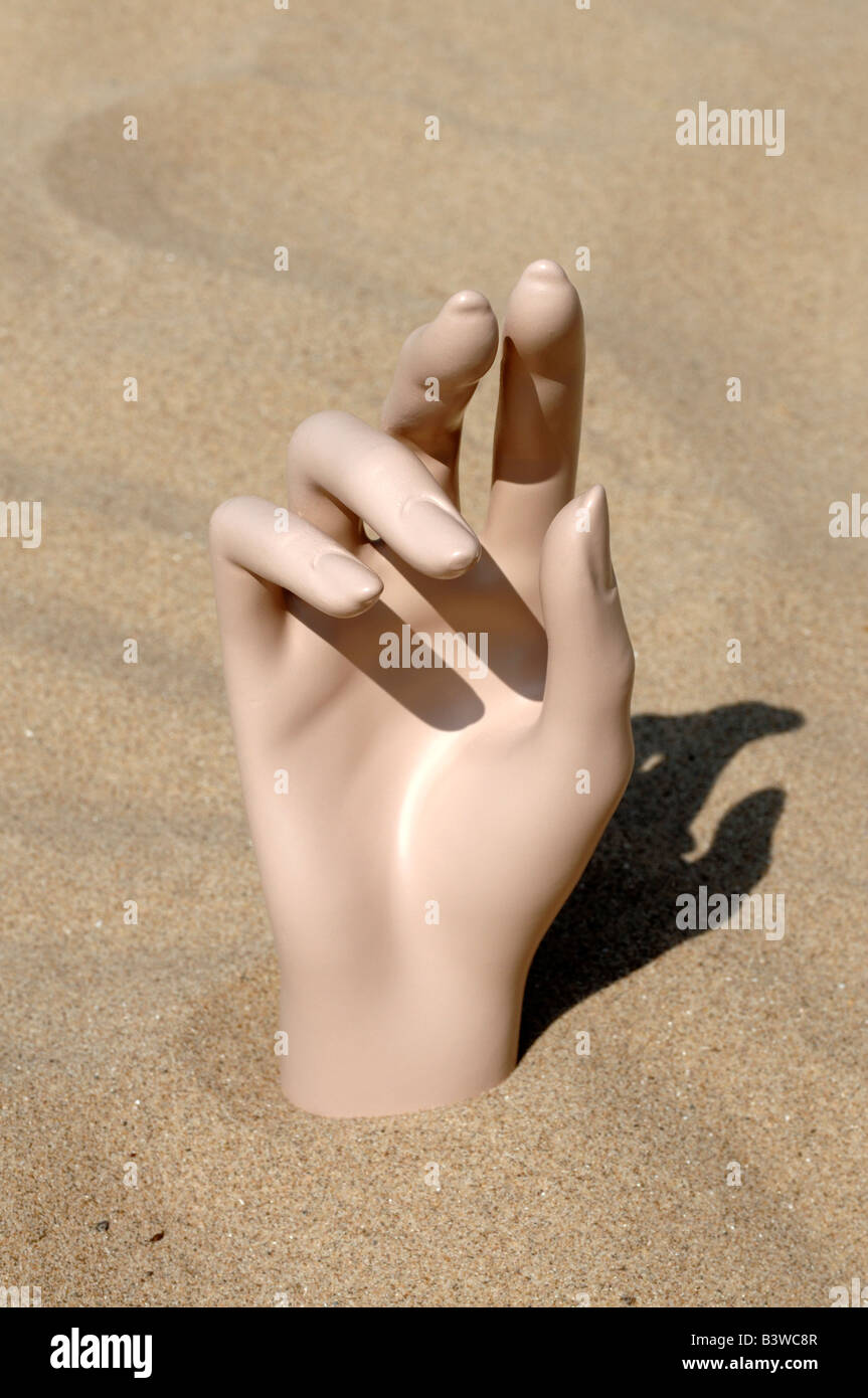Mannequin hand in sand Stock Photo