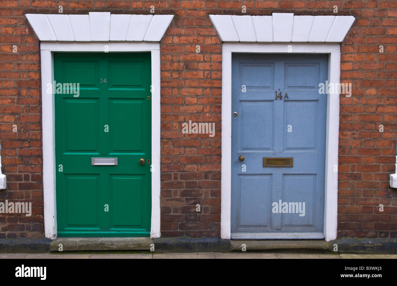 Green and blue six panel front doors with white frames of townhouses in Ludlow Shropshire England UK Stock Photo