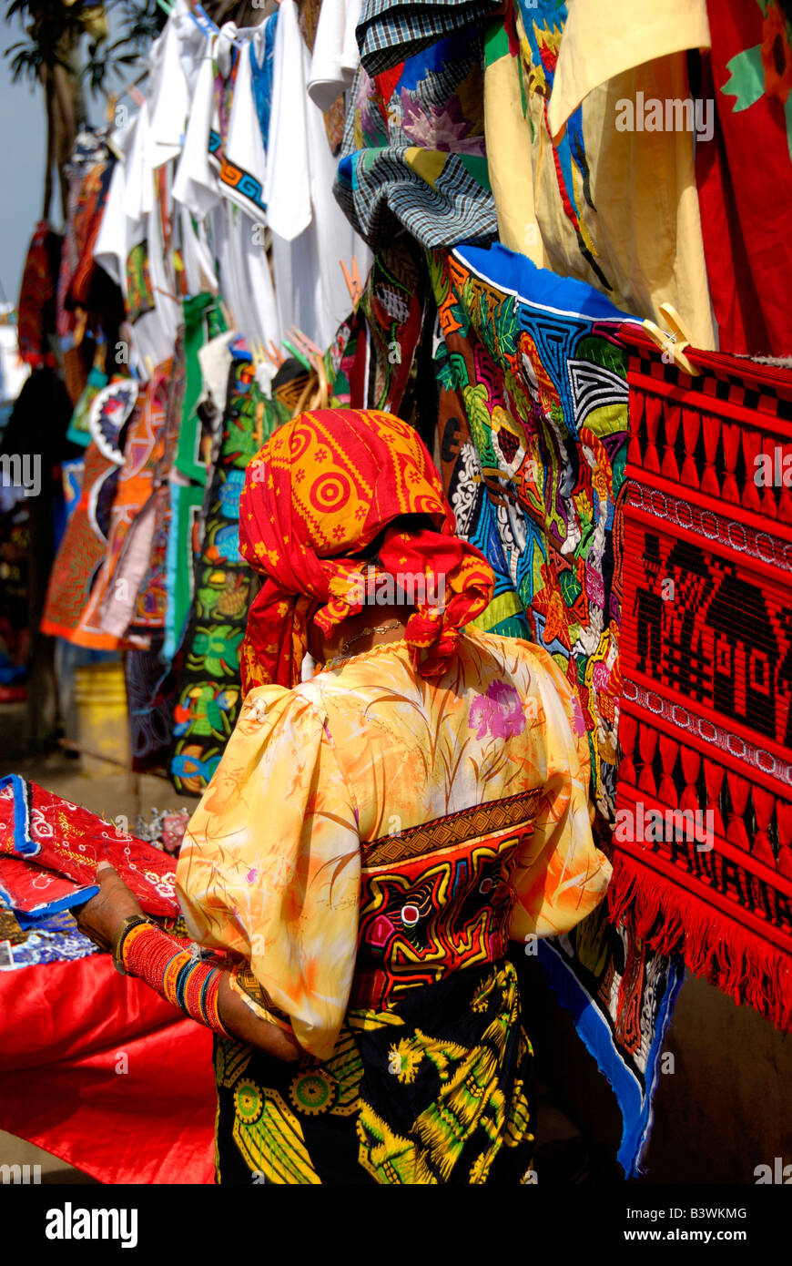 Central America, Panama, San Blas Islands. Kuna Indian in traditional attire in front of colorful hand stitched molas for sale. Stock Photo