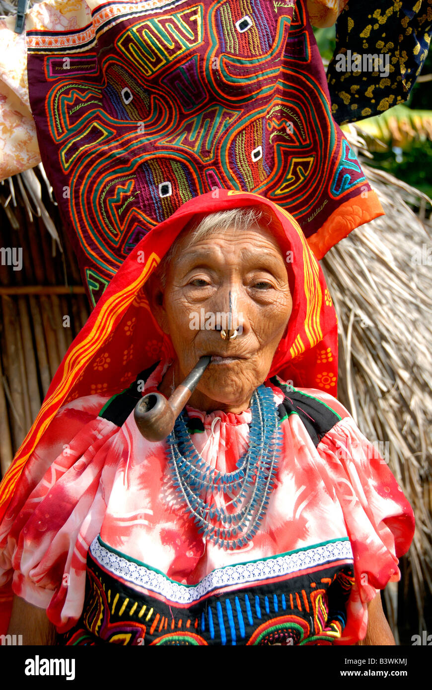 Central America, Panama, San Blas Islands. Kuna Indian woman in traditional attire in front of colorful hand stitched molas. Stock Photo