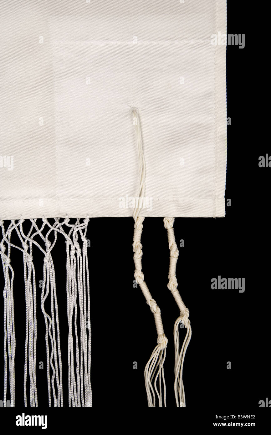 Fringes called tzitzit are sewn to the corners of a Jewish prayer shawl called a tallit isolated