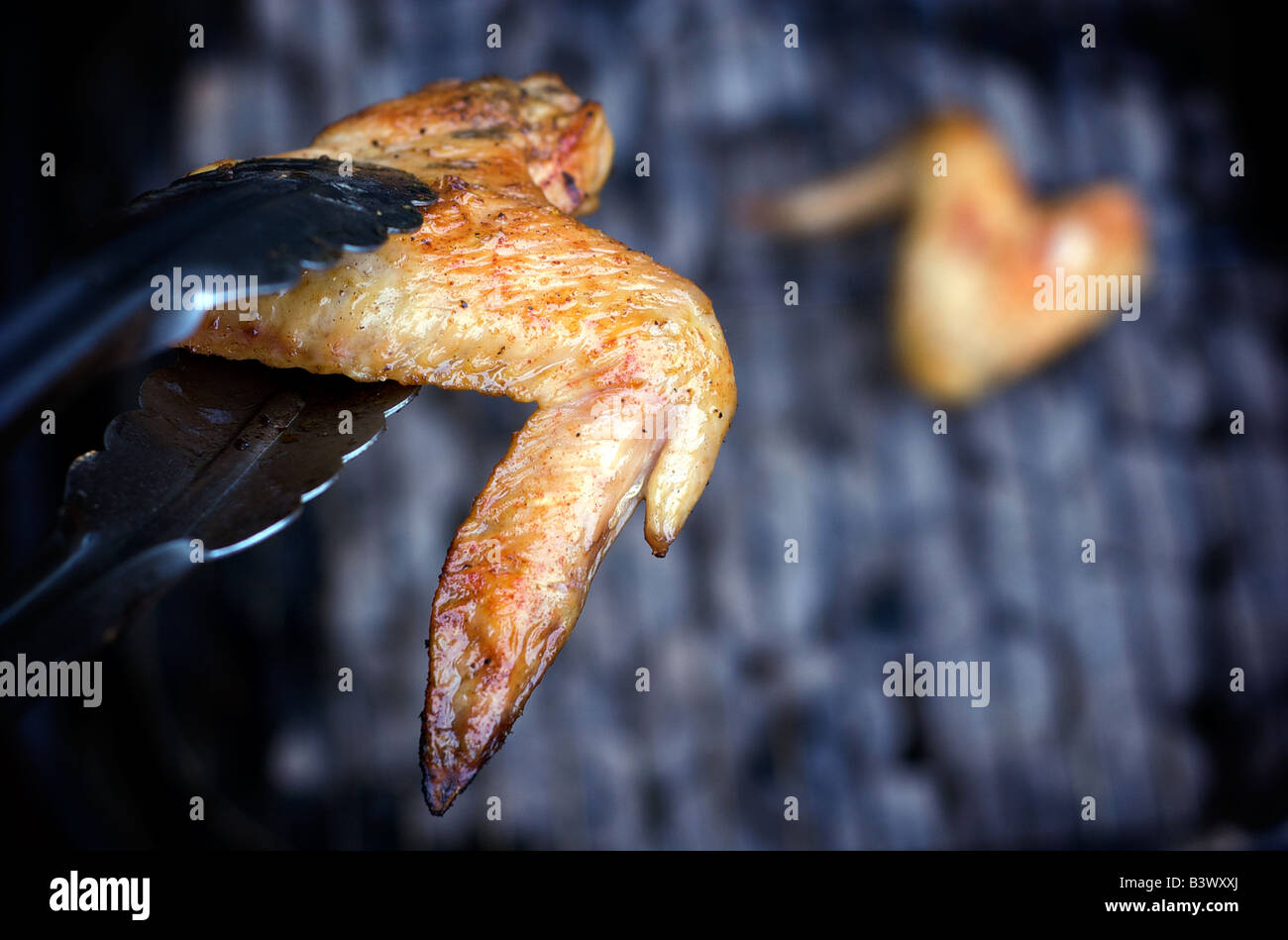 Closeup of BBQ Chicken Wings Over A Hibachi Grille Stock Photo