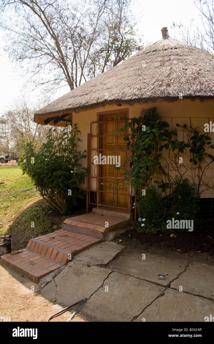 Traditional round mud hut with modern security door Zambia Africa Stock Photo