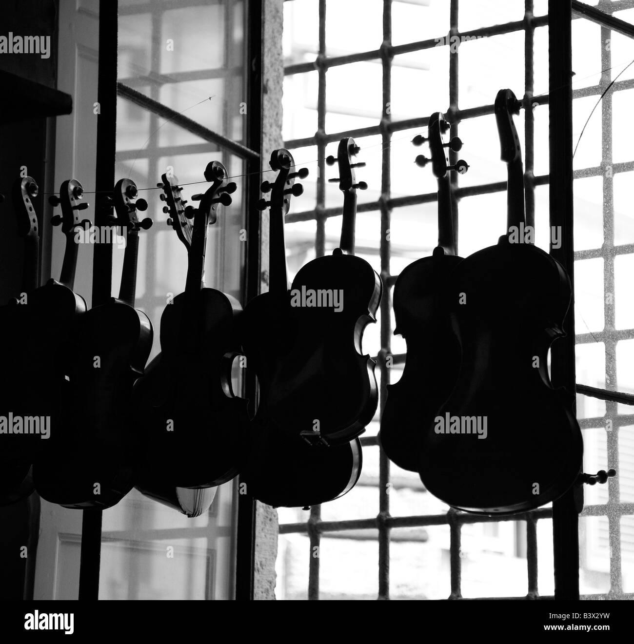 violins hanging on string in window Stock Photo Alamy