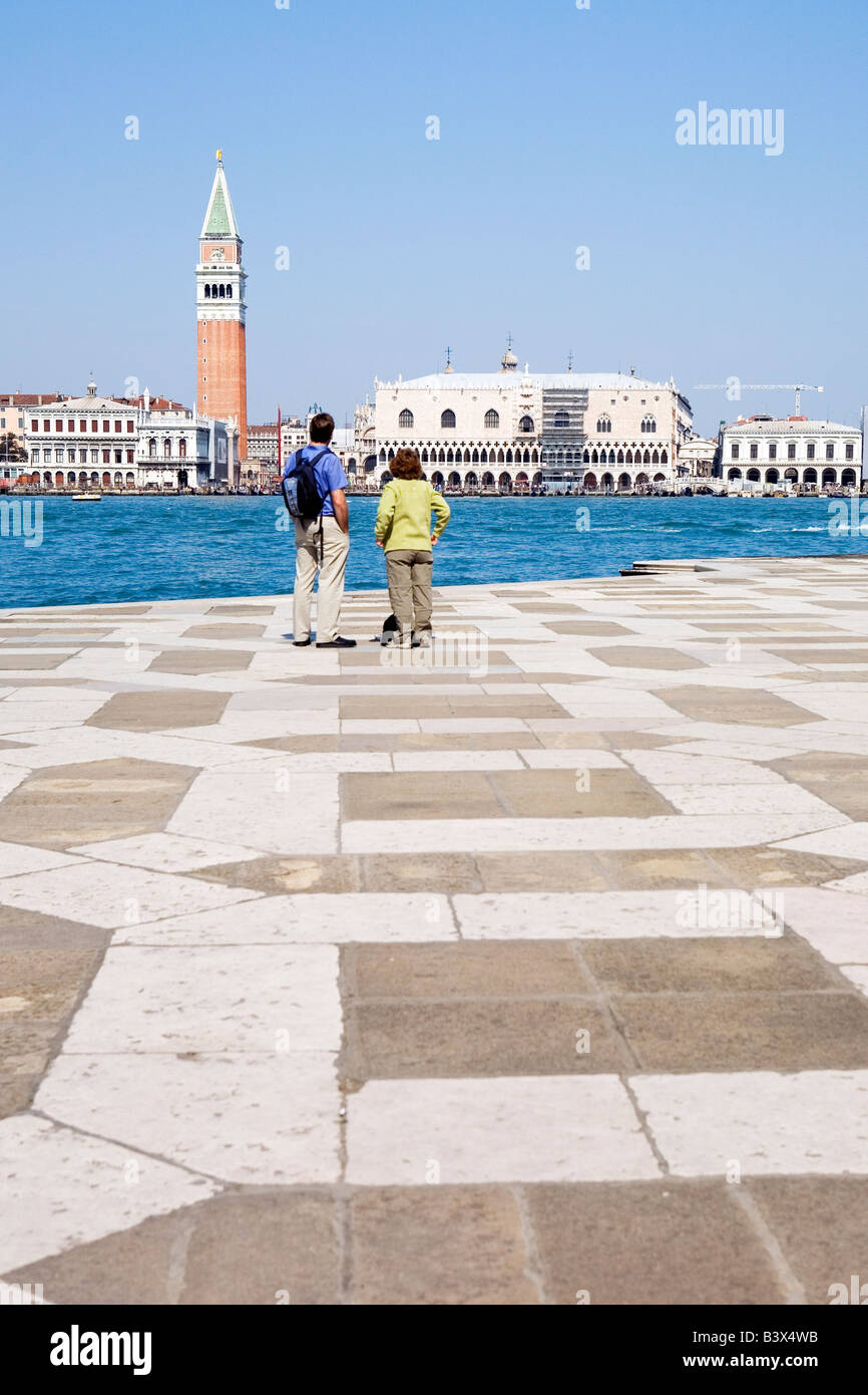 Couple take in the view over the Canale di San Marco towards Piazza San Marco from San Giorgio Maggiore Venice Italy Stock Photo