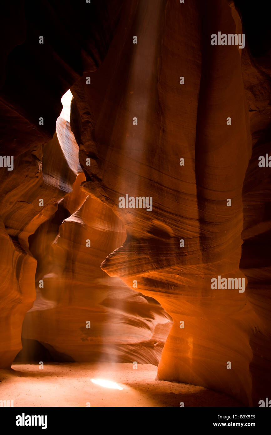 Tall streaming shaft of sunlight in colorful Antelope Canyon, formed by ...
