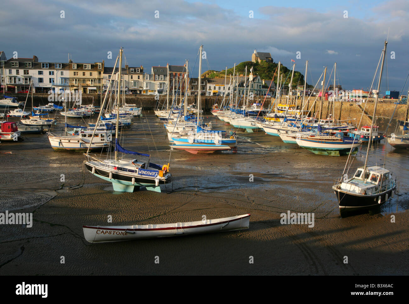 Boats moored at low tide at Ilfracombe harbour, Devon, England during the late afternoon Stock Photo