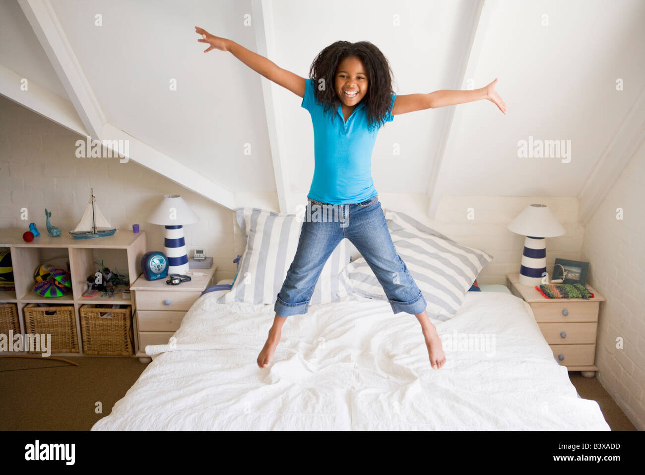 Young Girl Jumping On Her Bed Stock Photo Alamy