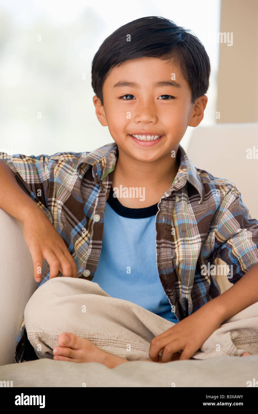 Young Boy Sitting On A Sofa At Home Stock Photo - Alamy