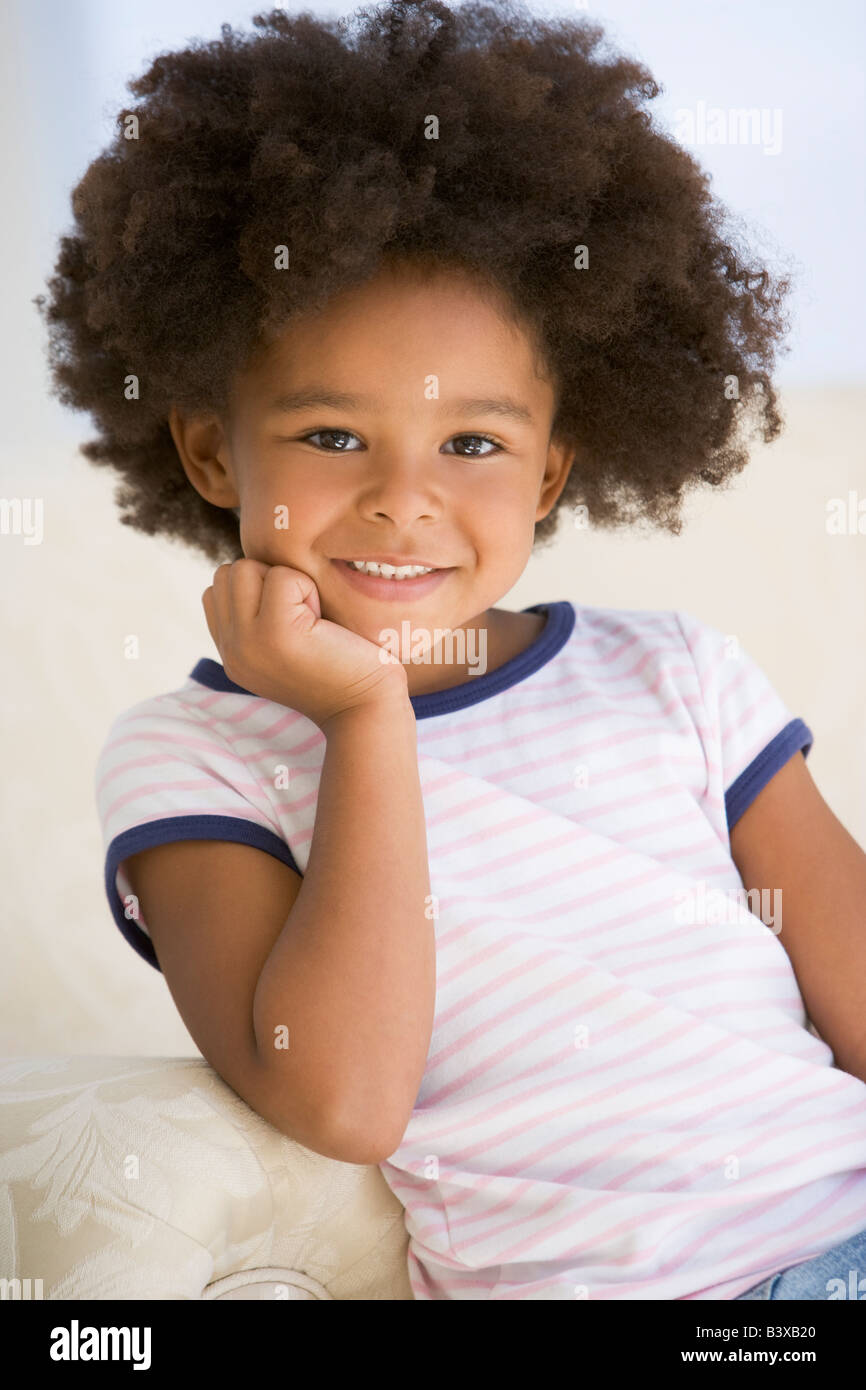 Young Girl Sitting On A Sofa Stock Photo - Alamy