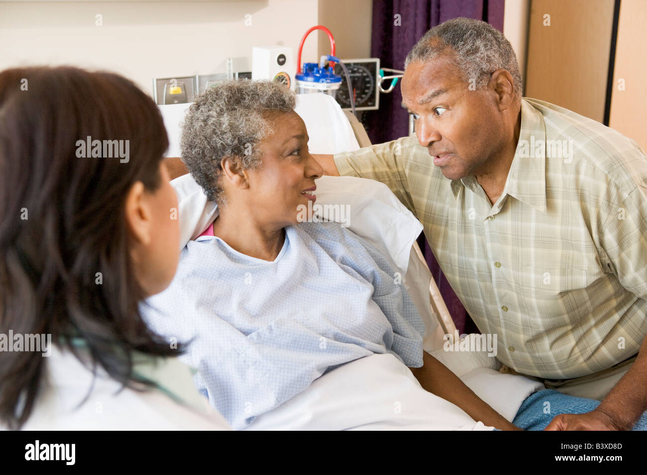 Doctor Explaining, Senior Couple Looking At Each Other Stock Photo