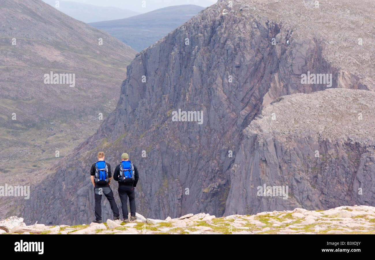 Two hillwalkers on the Cairngorm plateau looking over the head of Glen Avon to Cairn Etchachan and the Shelter Stone Crag Stock Photo