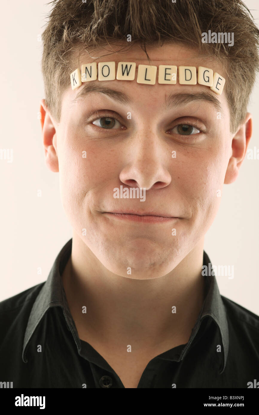 Man with the word 'knowledge' spelled with letter tiles on his head Stock Photo