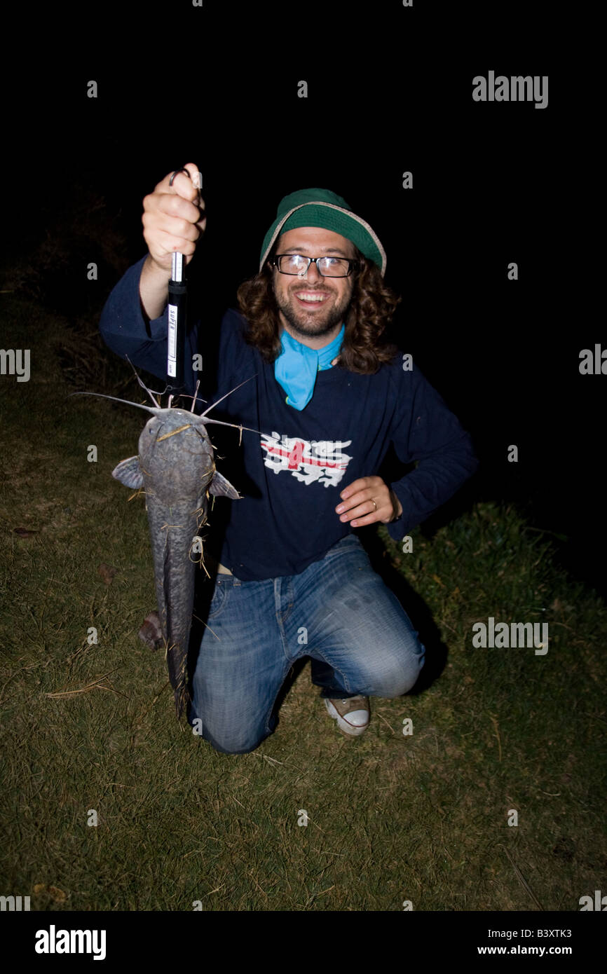 Fisherman with a large barbell catfish caught at night when they feed