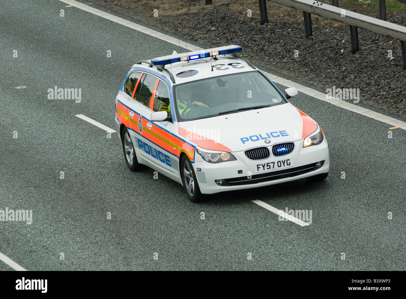 Bmw police car speeding along a motorway to an incident with blue flashing lights and siren on Stock Photo