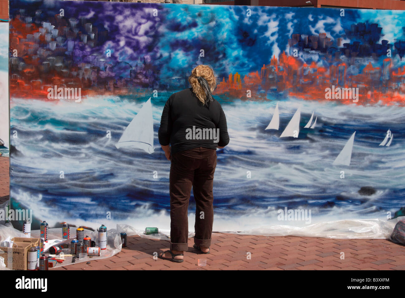 Female graffiti artist painting surf scene on wall Stock Photo Alamy
